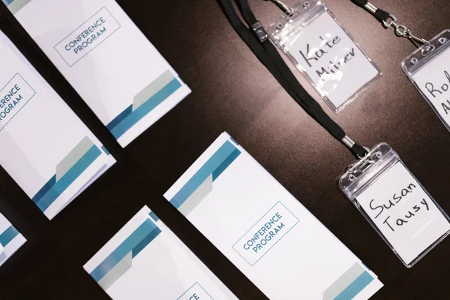 High-angle view of conference programs and name badges on a table, ideal for corporate event visuals. Seasonal promotional merchandise in the UK compared across trade show calendars
